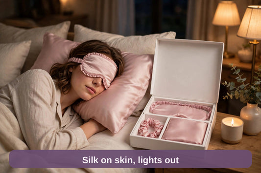 Woman asleep wearing the blush pink silk eye mask on the silk pillowcase, gift box on the nightstand — silk on skin, lights out