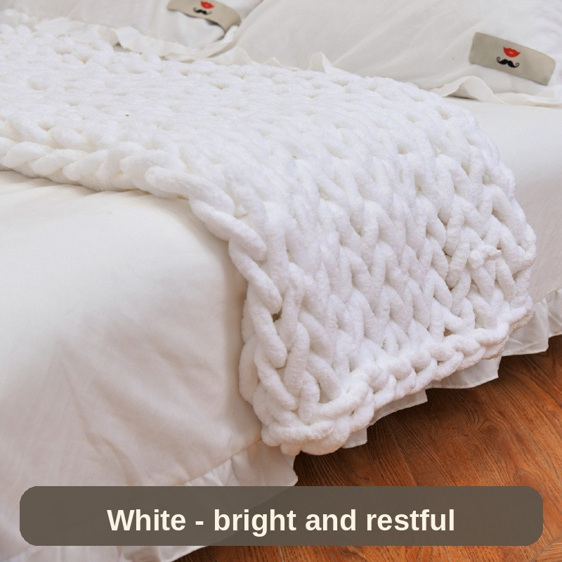 White weighted blanket draped over the bed corner - bright and restful for a minimalist room.