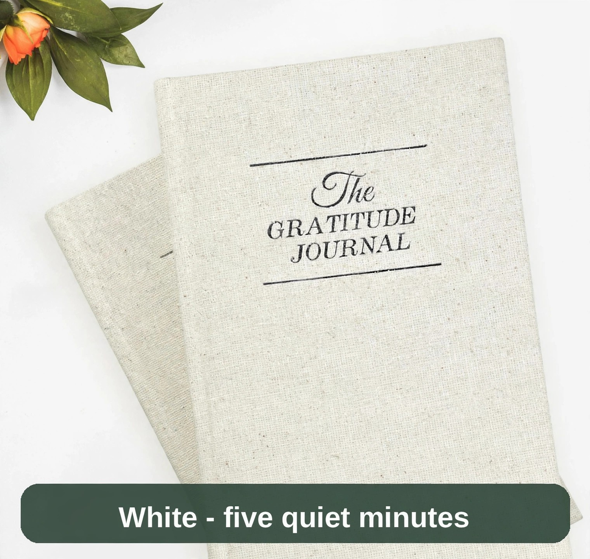The Gratitude Journal in a white linen finish, resting beside soft greenery - five quiet minutes to end the day.
