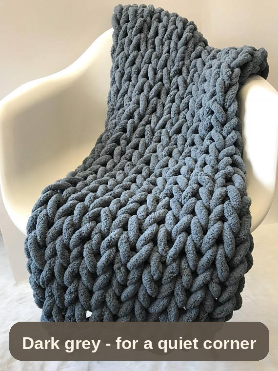Knitted Weighted Blanket in dark grey draped over a chair - deep, calming colour for a quiet corner.