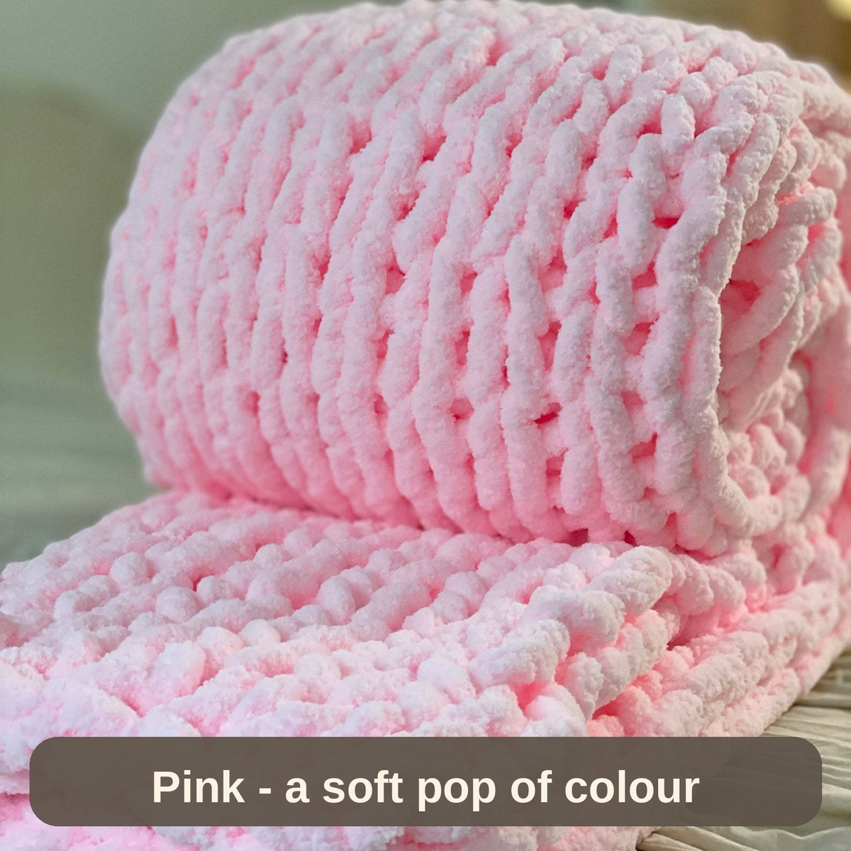 Pink weighted blanket rolled on the bed - a soft pop of colour with a reassuring weight.